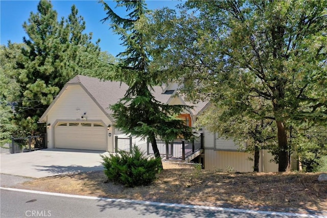 view of property hidden behind natural elements with a garage