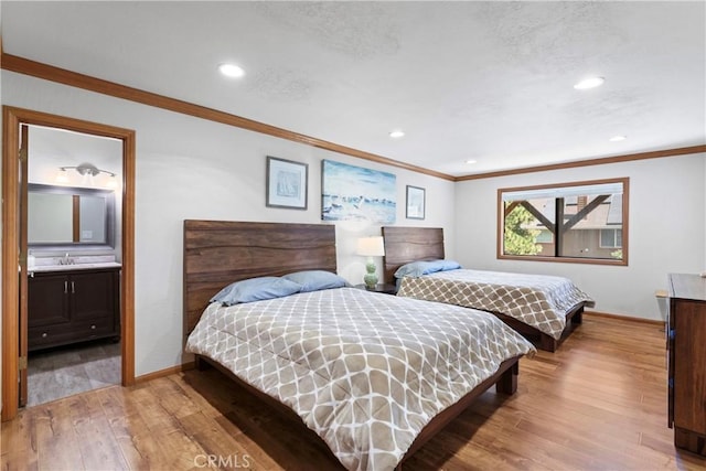 bedroom with ensuite bathroom, crown molding, and light hardwood / wood-style floors