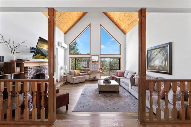 living room with hardwood / wood-style floors, an AC wall unit, high vaulted ceiling, and a brick fireplace