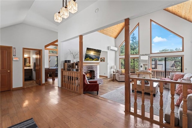 bedroom with a wall mounted air conditioner, high vaulted ceiling, ensuite bathroom, hardwood / wood-style floors, and a fireplace