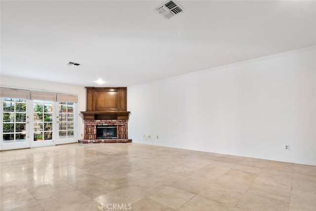 unfurnished living room with crown molding, a fireplace, and french doors