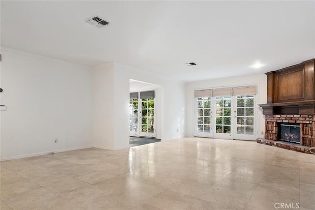 unfurnished living room with a fireplace and french doors