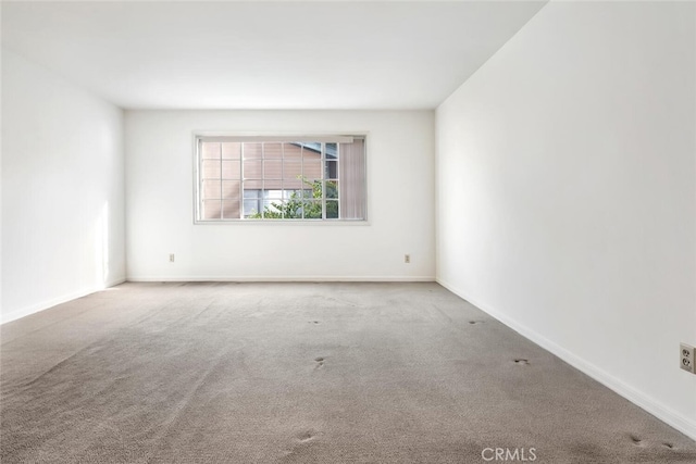 unfurnished room featuring light carpet