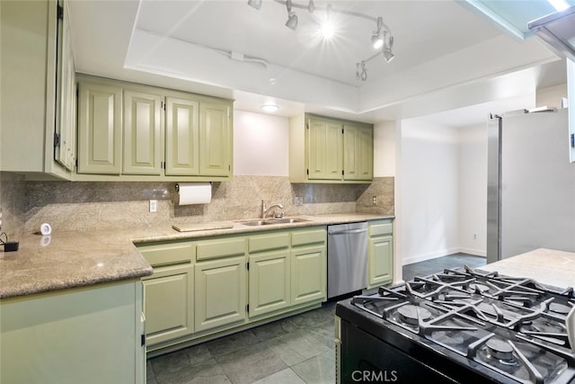 kitchen featuring tasteful backsplash, stainless steel appliances, a tray ceiling, sink, and green cabinetry