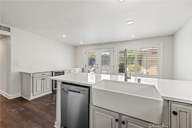 kitchen featuring wine cooler, sink, stainless steel dishwasher, light stone countertops, and dark hardwood / wood-style flooring