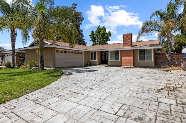 ranch-style house featuring a front lawn and a garage