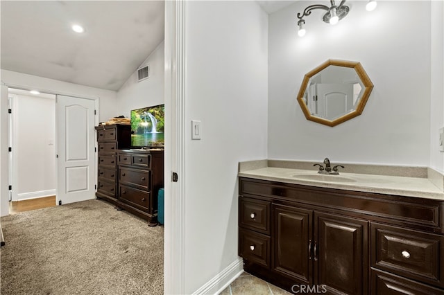 bathroom with vanity and vaulted ceiling