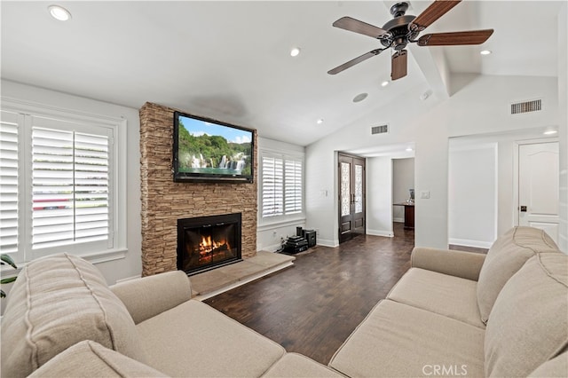 living room featuring vaulted ceiling with beams, a fireplace, ceiling fan, and dark wood-type flooring