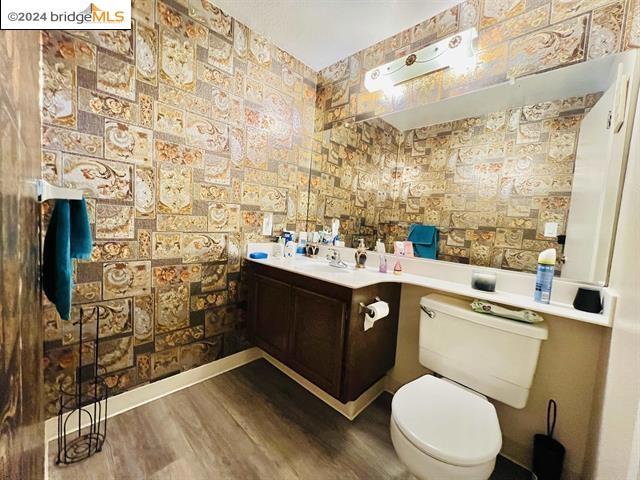 bathroom featuring wood-type flooring, vanity, and toilet