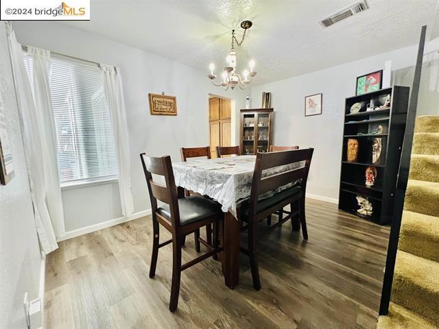 dining room with hardwood / wood-style floors and a notable chandelier