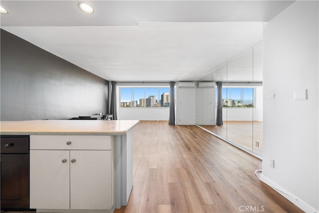 kitchen featuring white cabinets, light hardwood / wood-style flooring, and plenty of natural light