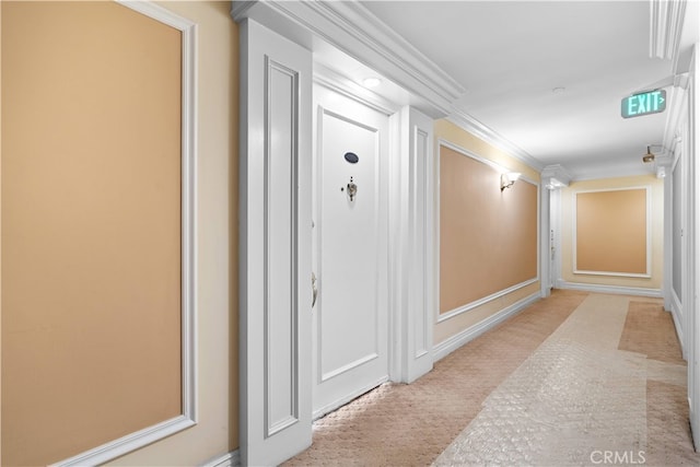 hallway with ornamental molding and light colored carpet