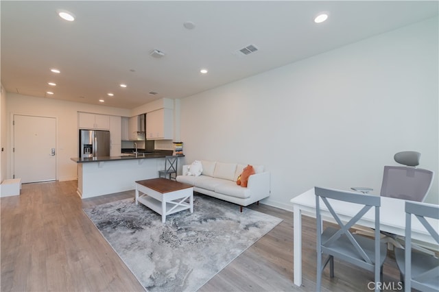 living room featuring light hardwood / wood-style floors and sink