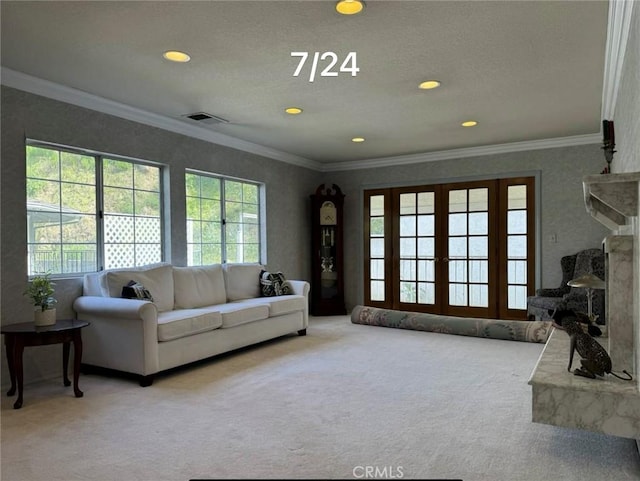 living room featuring carpet, a textured ceiling, and ornamental molding