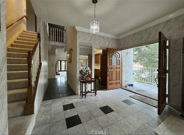 foyer with a notable chandelier and crown molding