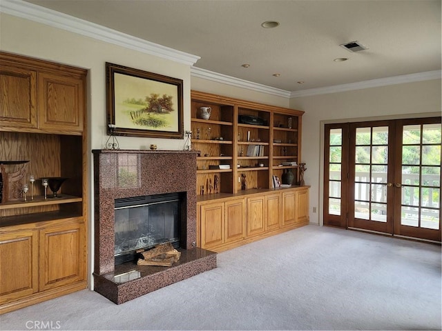 living room featuring light colored carpet, ornamental molding, french doors, and a premium fireplace