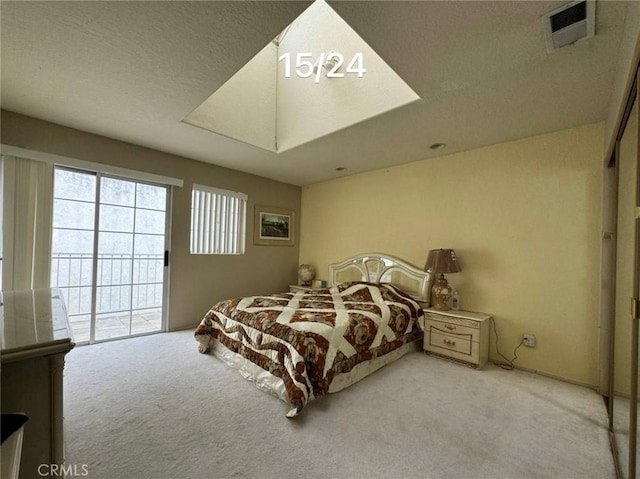 bedroom featuring access to exterior, light colored carpet, and a textured ceiling