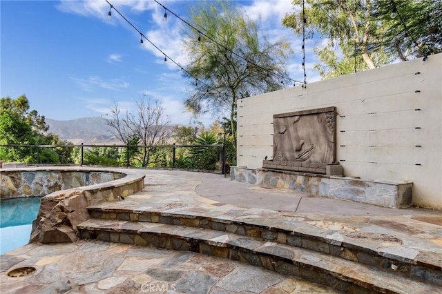 view of patio with a mountain view and a fenced in pool