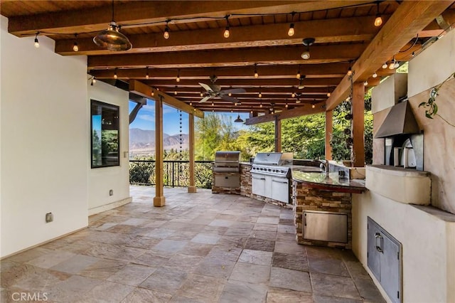 view of patio / terrace featuring area for grilling, a mountain view, sink, ceiling fan, and grilling area