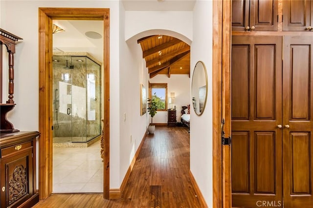 hall with hardwood / wood-style flooring, wooden ceiling, and vaulted ceiling with beams