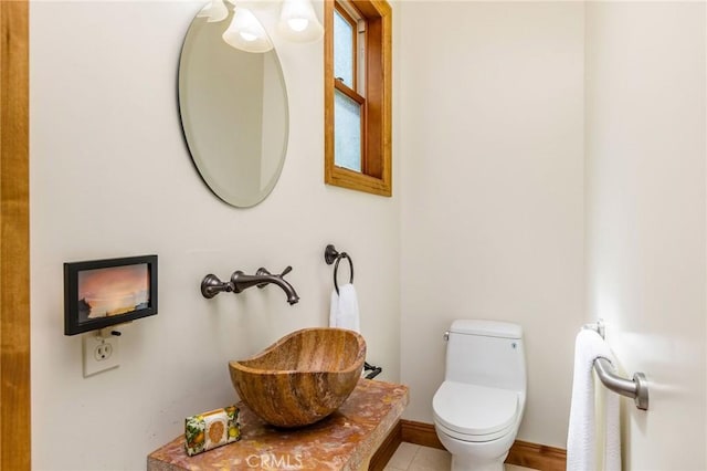 bathroom with sink, toilet, and tile patterned floors