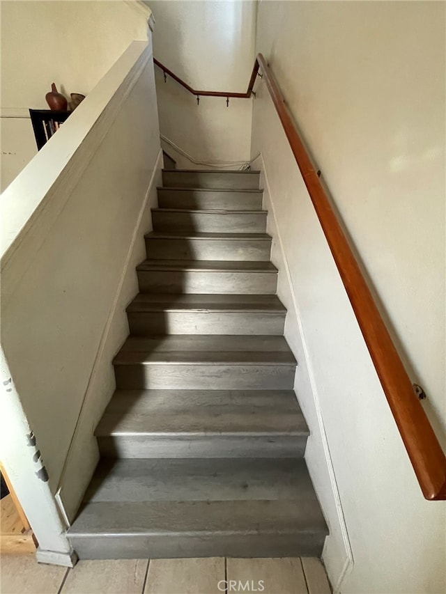 staircase featuring tile patterned flooring