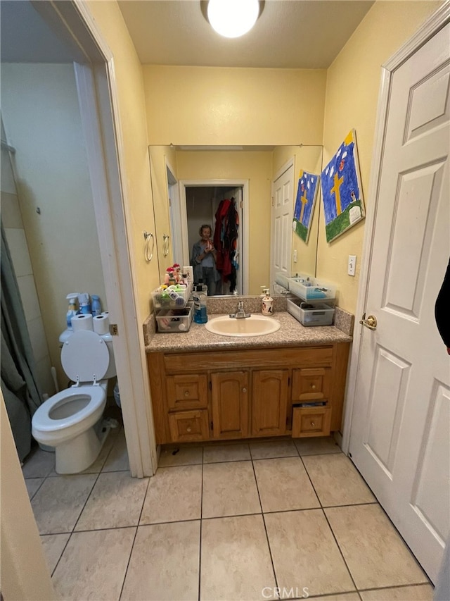 bathroom with tile patterned flooring, vanity, and toilet