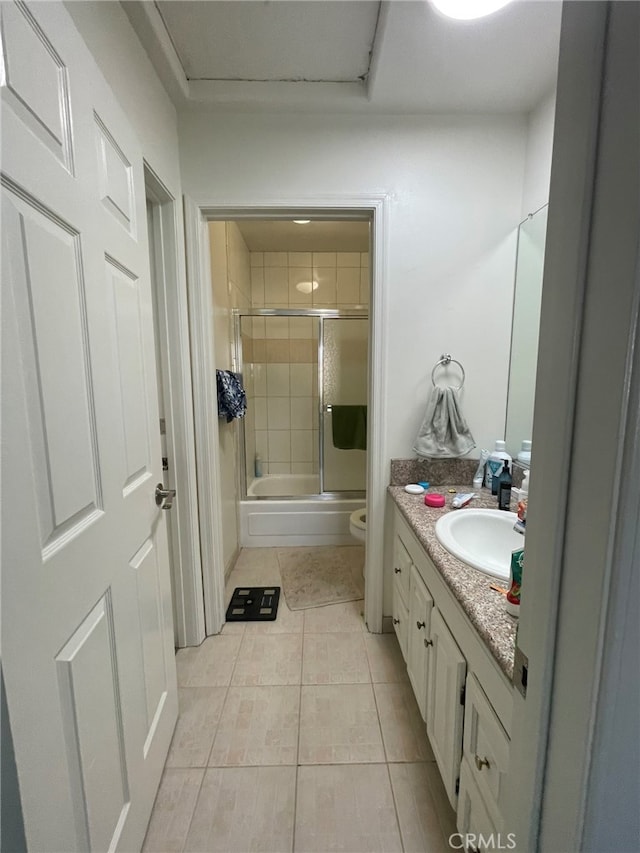 full bathroom with shower / bath combination with glass door, vanity, toilet, and tile patterned floors