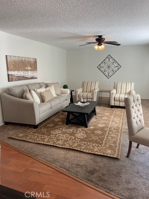 living room featuring ceiling fan, hardwood / wood-style flooring, and a textured ceiling