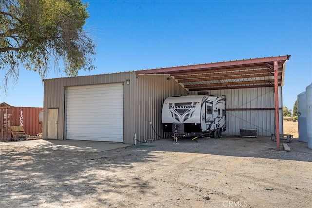 garage with wooden walls and a carport