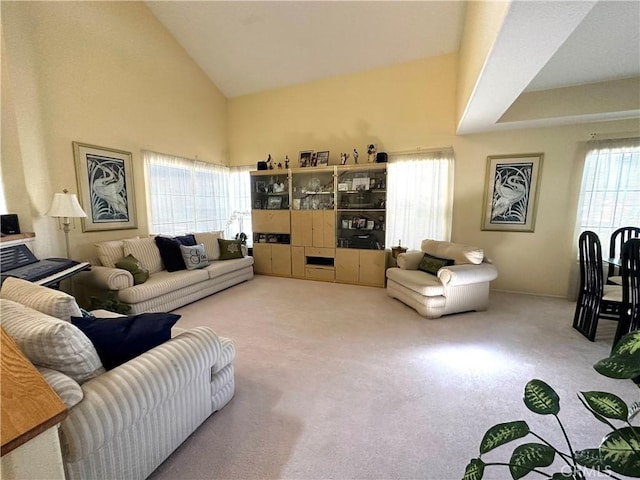 carpeted living room featuring high vaulted ceiling