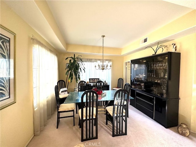 carpeted dining area featuring a chandelier