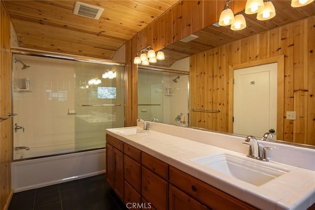 bathroom with tile patterned flooring, wood walls, combined bath / shower with glass door, vanity, and wood ceiling