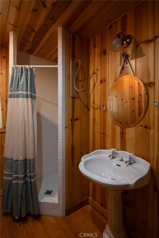 bathroom featuring wood walls, wooden ceiling, vaulted ceiling, hardwood / wood-style flooring, and a shower with shower curtain