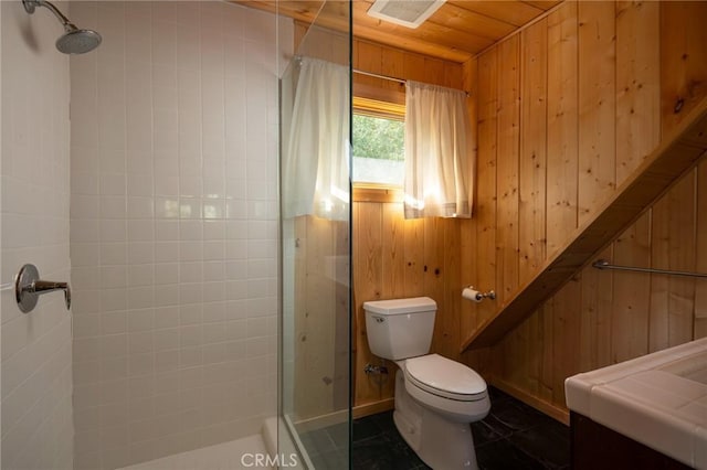 bathroom with wood ceiling, wooden walls, tiled shower, tile patterned flooring, and toilet