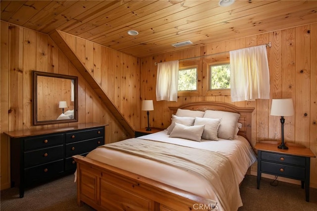 bedroom featuring wood walls, wood ceiling, and dark carpet