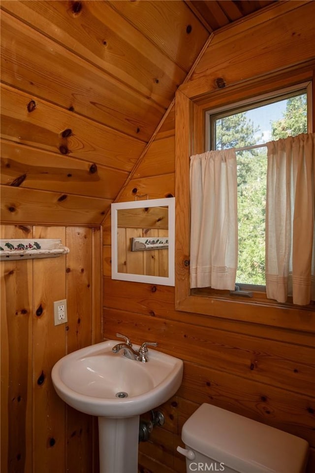 bathroom featuring wood walls, toilet, lofted ceiling, and wood ceiling