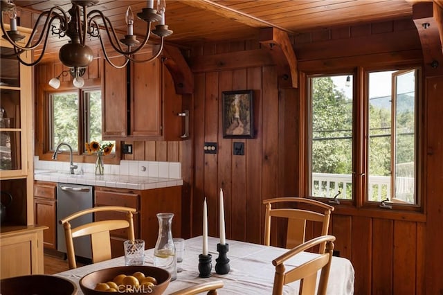 kitchen featuring sink, tile counters, and wood walls