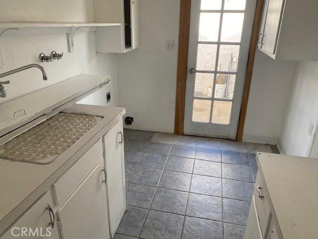 laundry area featuring hookup for an electric dryer, light tile patterned flooring, hookup for a washing machine, cabinets, and sink