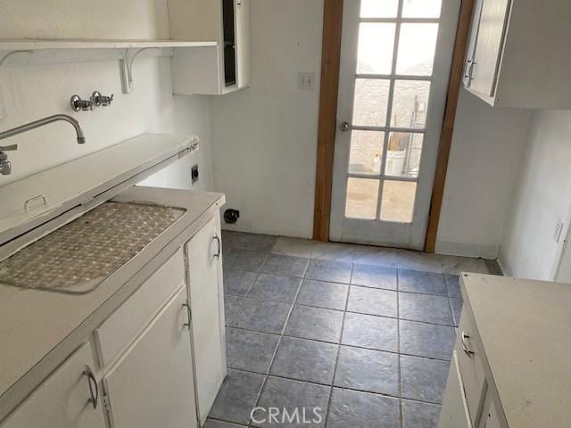 laundry area with sink, cabinets, light tile patterned floors, electric dryer hookup, and washer hookup