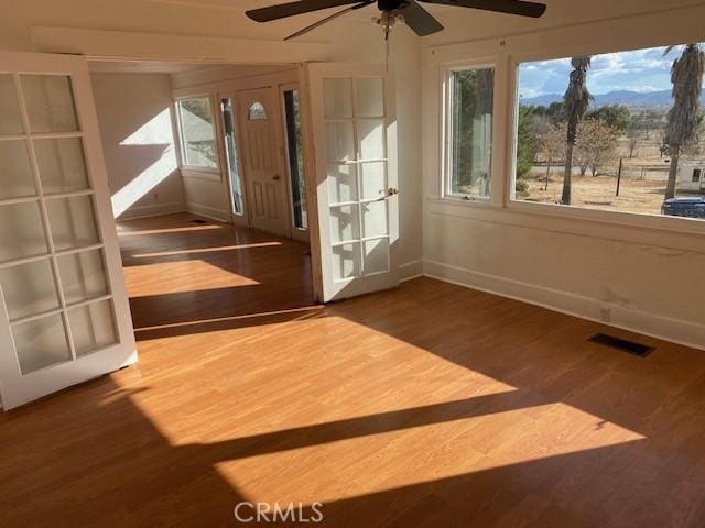 unfurnished sunroom featuring ceiling fan