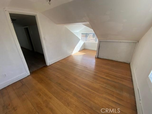 bonus room with light wood-type flooring and lofted ceiling