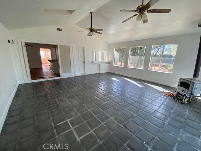 unfurnished living room with vaulted ceiling, ceiling fan, and a wood stove