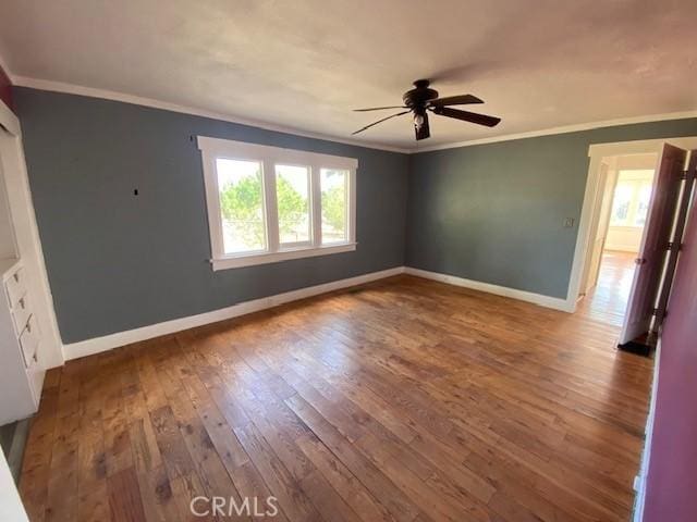 empty room with ceiling fan, hardwood / wood-style floors, and crown molding