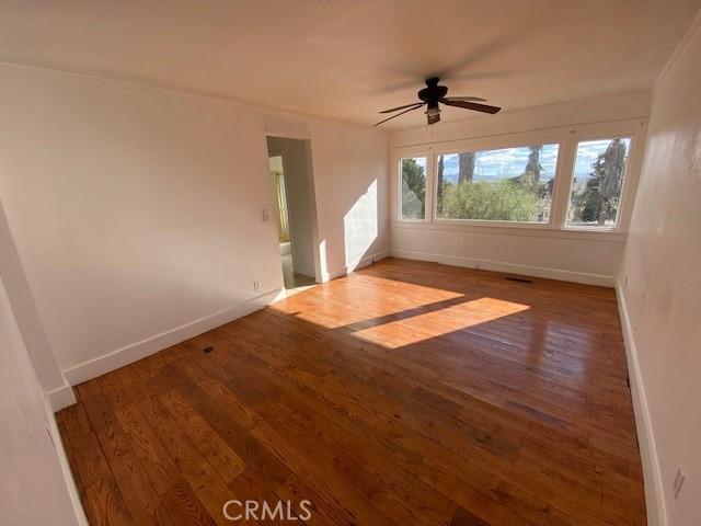 unfurnished room with ceiling fan and wood-type flooring