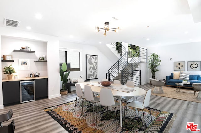 dining area featuring an inviting chandelier, beverage cooler, and light hardwood / wood-style flooring