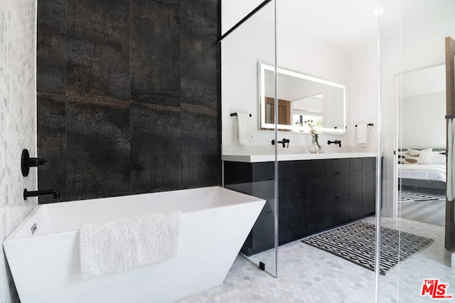 bathroom with a bathtub, vanity, and tile patterned flooring