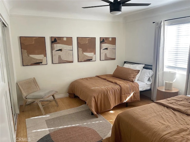 bedroom with ornamental molding, light wood-type flooring, and ceiling fan