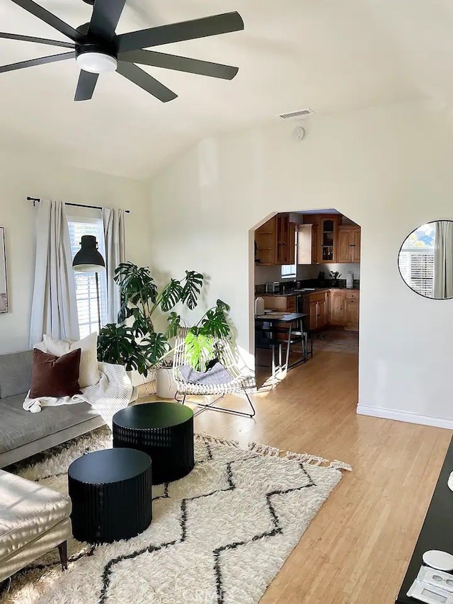 living room featuring light wood-type flooring, lofted ceiling, and ceiling fan