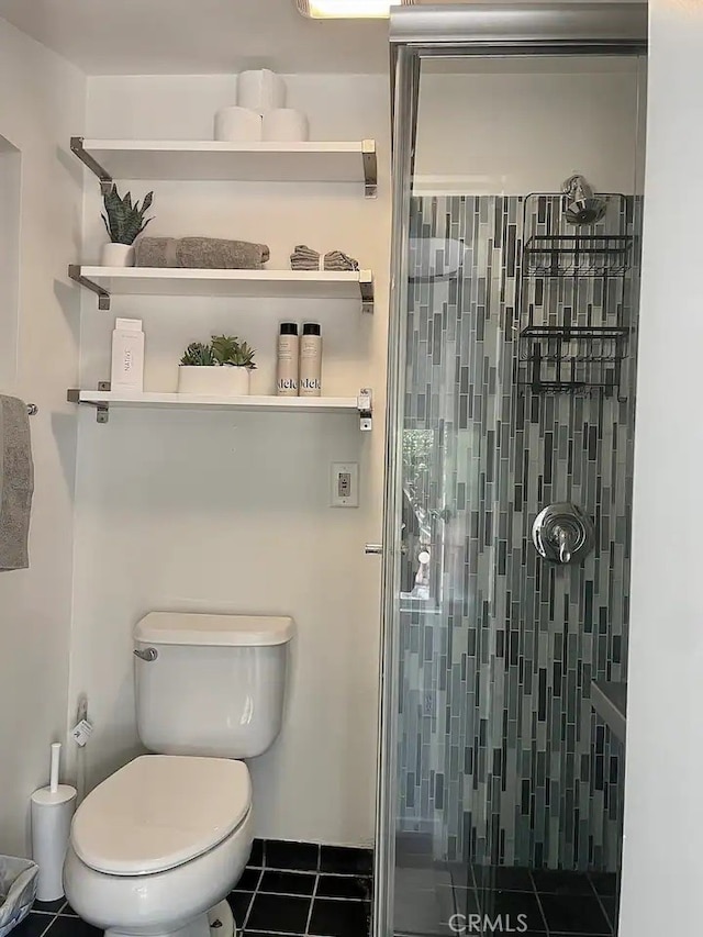 bathroom with tile patterned flooring, toilet, and a shower with door